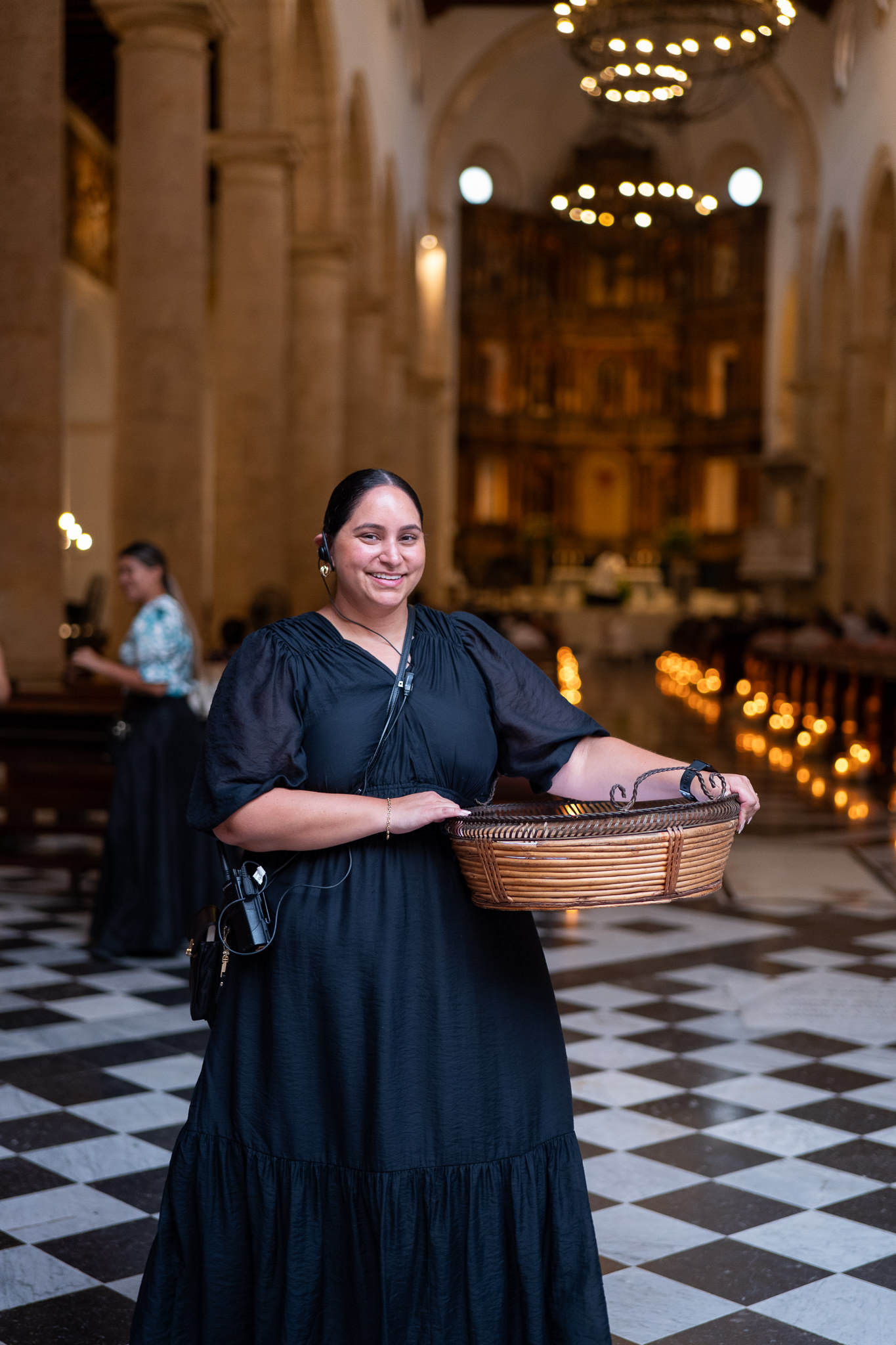 wedding planner in cartagena colombia waiting on the wedding guests arrival holding a basket with fans for the ceremony
